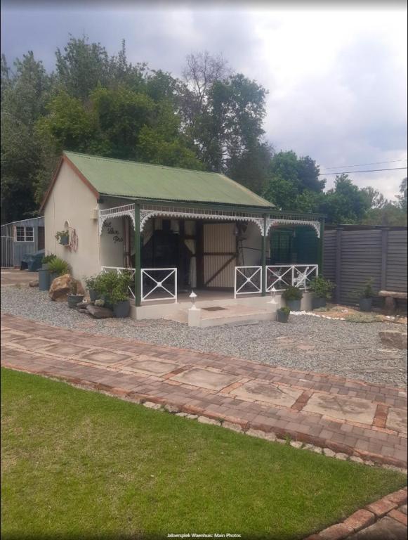 a small house with a green roof and a patio at Die Waenhuis in Parys
