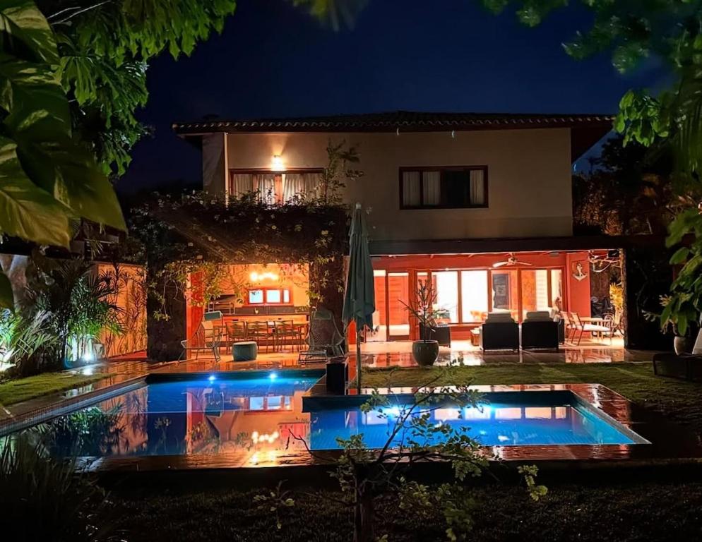 a house with a swimming pool at night at Canto das Pedras House in Mata de Sao Joao