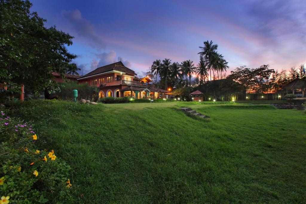a large house with a lawn in front of it at The River Retreat Heritage Ayurvedic Resort in Shoranūr