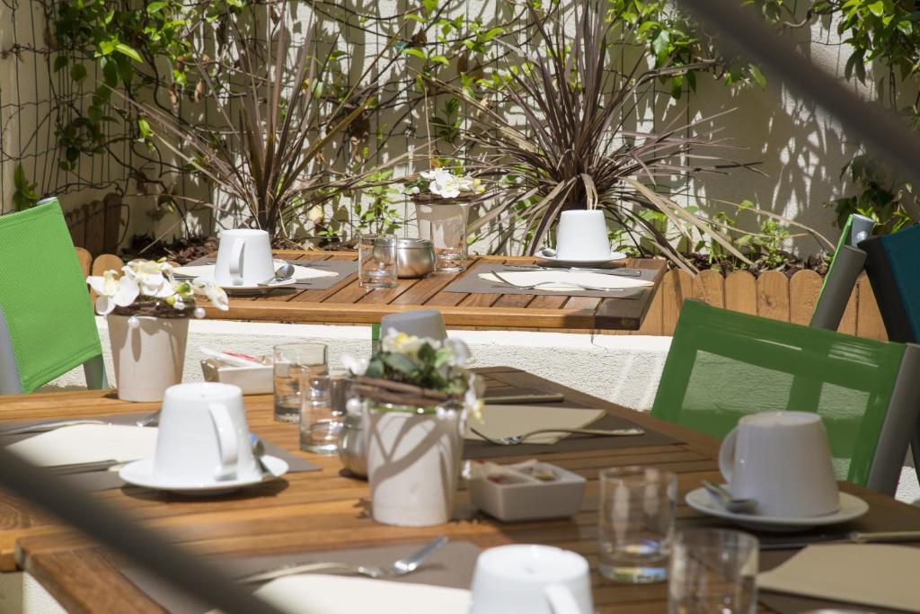 a wooden table with plates and napkins on it at Cristal Hôtel & Spa in Cannes