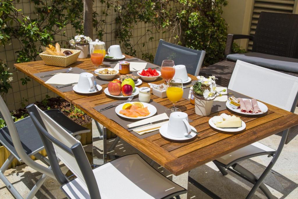 a wooden table with breakfast food on it at Cristal Hôtel & Spa in Cannes