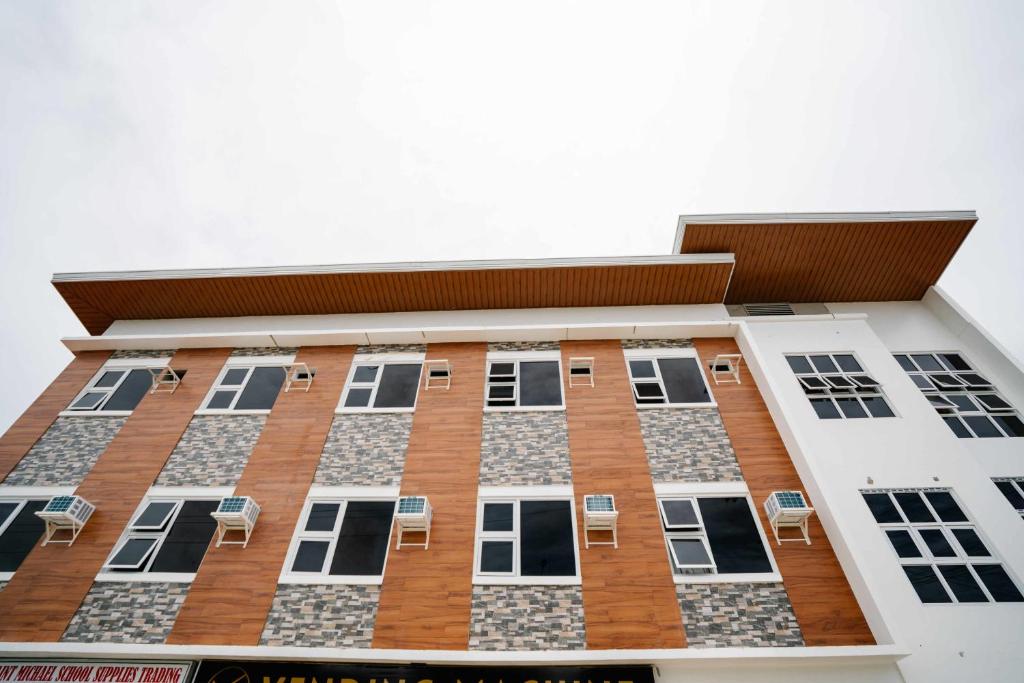 a tall building with chairs in front of it at MGM Tourist Inn in Tagbilaran City