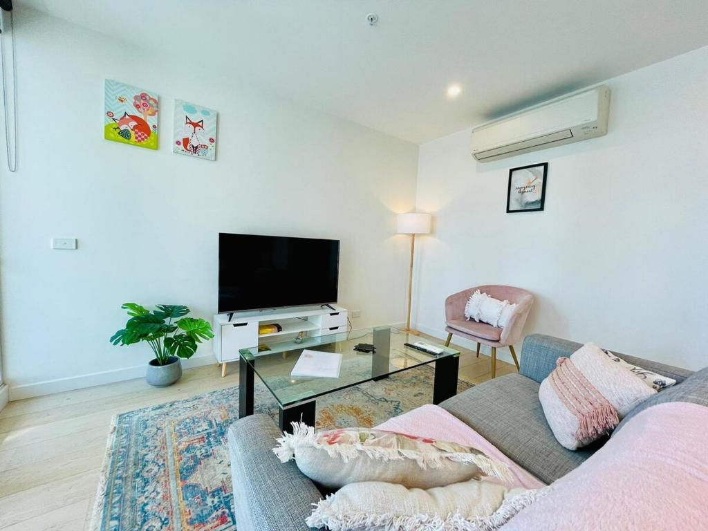 a living room with a couch and a tv at Comfy Unit in front of Crown with Free Parking in Melbourne