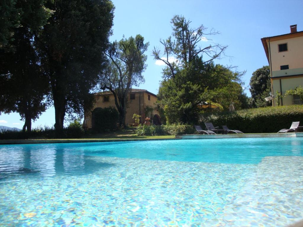 a swimming pool with blue water in a yard at Villa Pieve De' Pitti in Terricciola