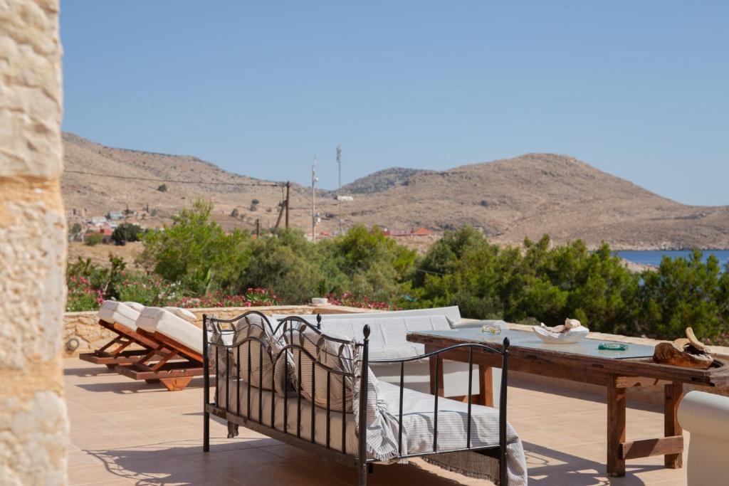 Un patio con mesa y sillas y vista al agua. en Villa Aristoteles, en Halki