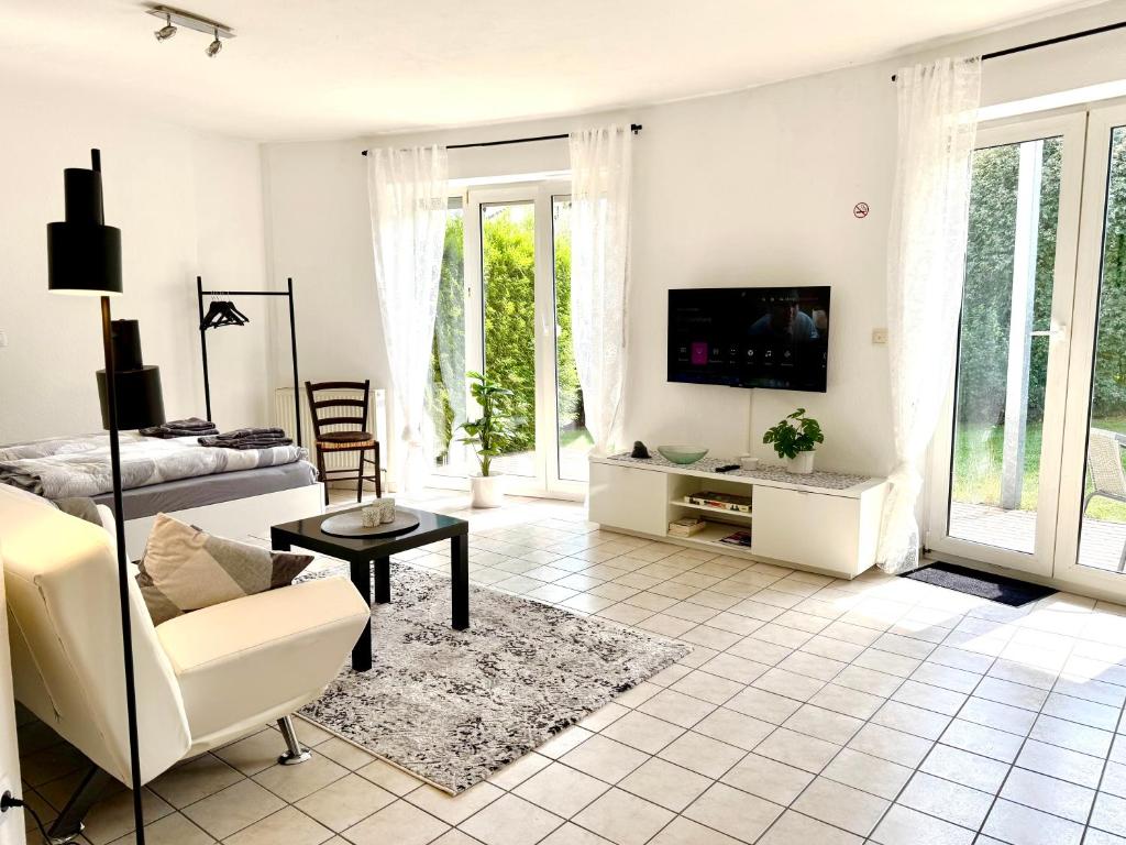 a living room with a couch and a tv at Kleines Idyll, Ruhig & erholsam - Peter M22 - Frankenwald Apartments in Stadtsteinach