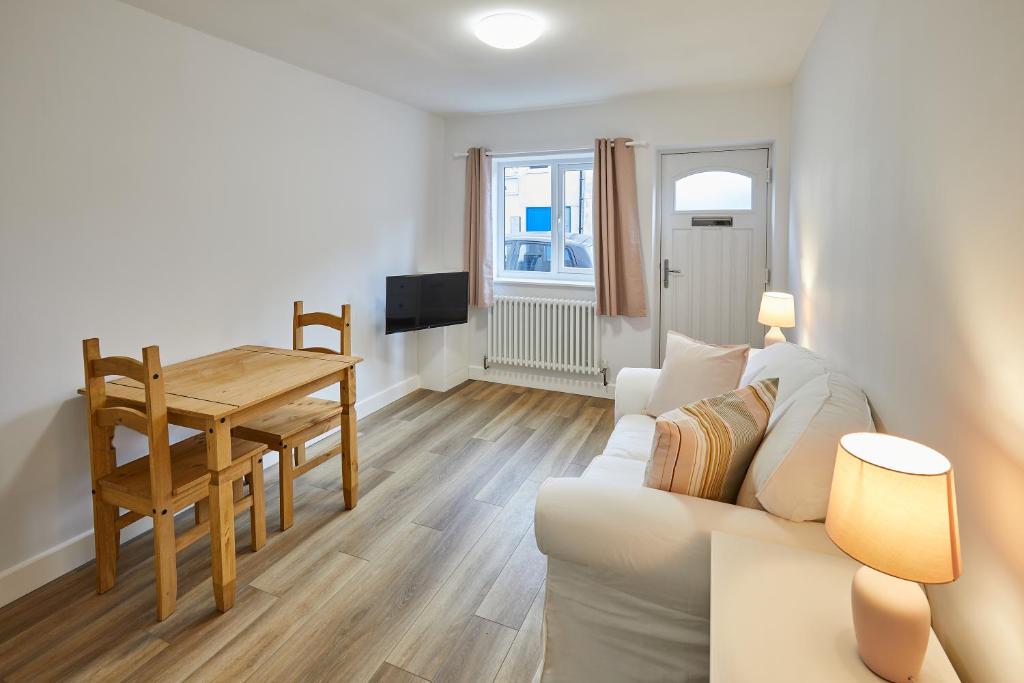 a living room with a white couch and a table at 94 Roseberry Cottage in the market town of Guisborough in Guisborough