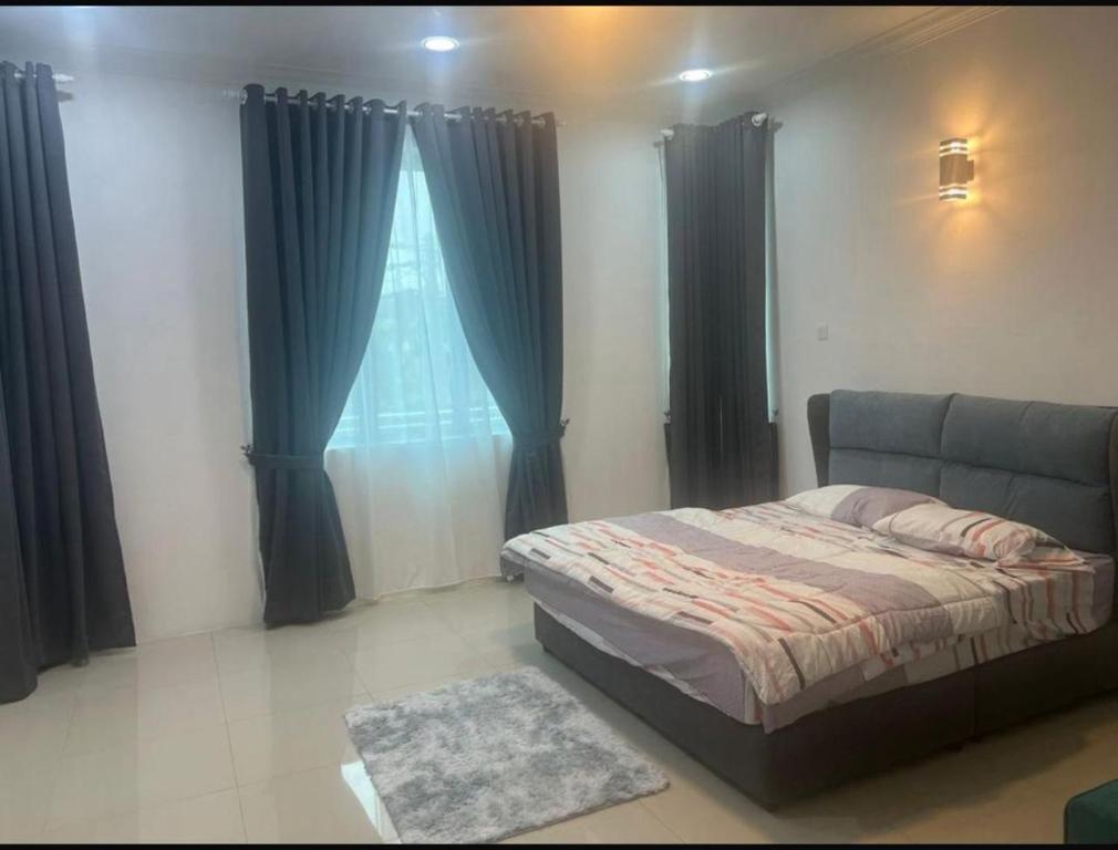 a bedroom with a bed and a window with curtains at Homestay in Mentekab