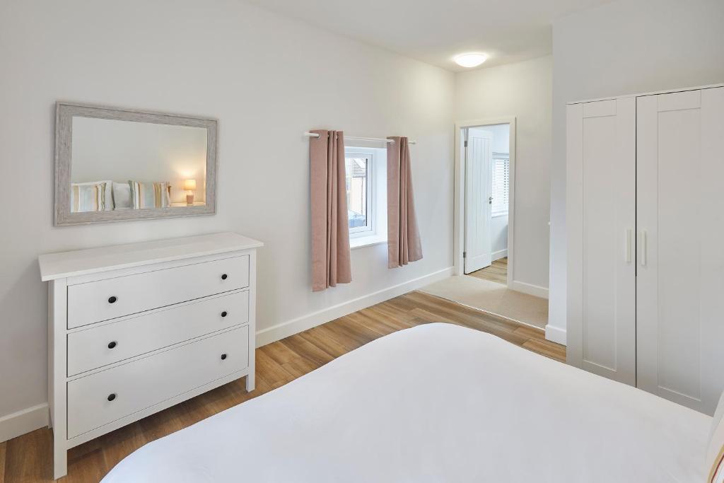 a bedroom with a white dresser and a mirror at 96 Roseberry Cottage in the market town of Guisborough in Guisborough
