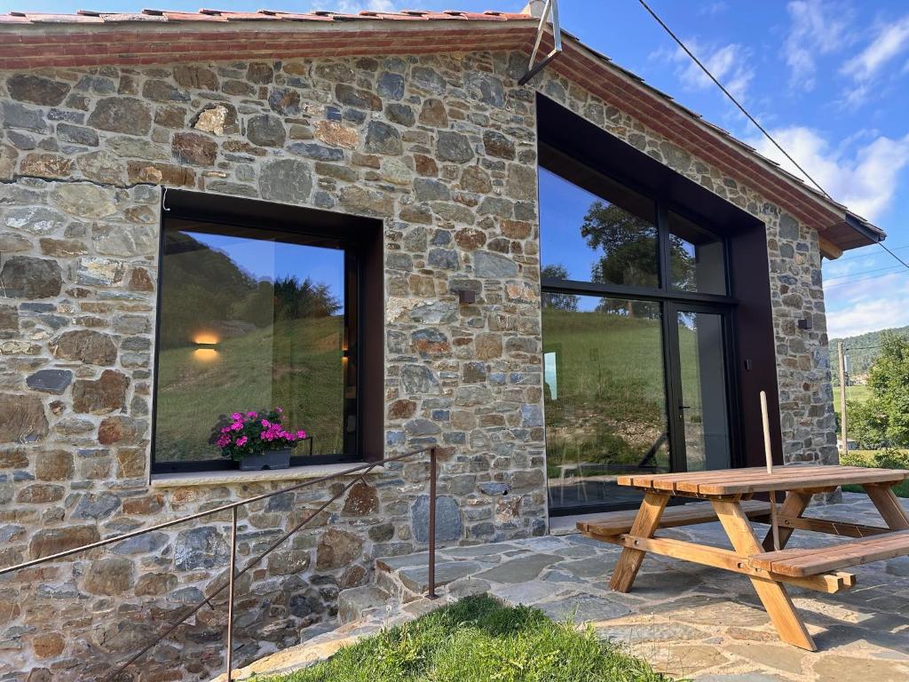 a stone cottage with a picnic table outside at La Cabanya de Can Ganasta in Sant Pau de Seguries