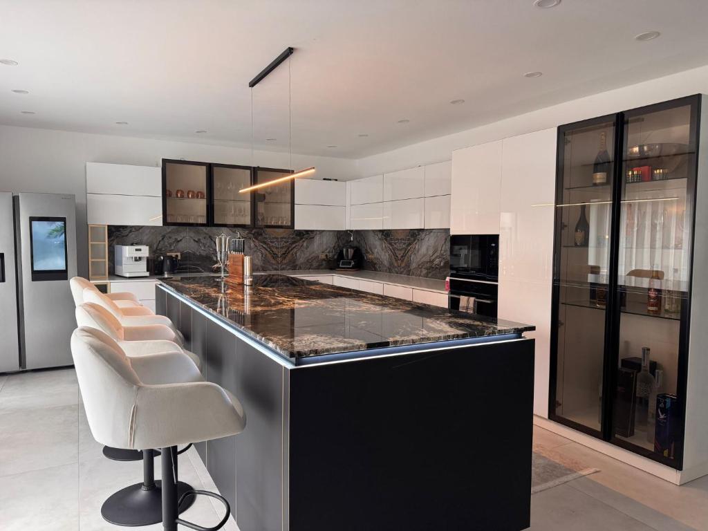 cocina con encimera y sillas en blanco y negro en Die Stadtvilla, en Holzminden