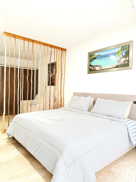 a white bed in a white room with a large bed at NEW Luxury Modern Condo by Menesse in Playa del Carmen