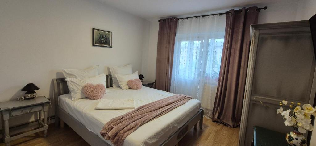 a small bedroom with a bed with a window at Vintage Central Apartament in Târgu Jiu