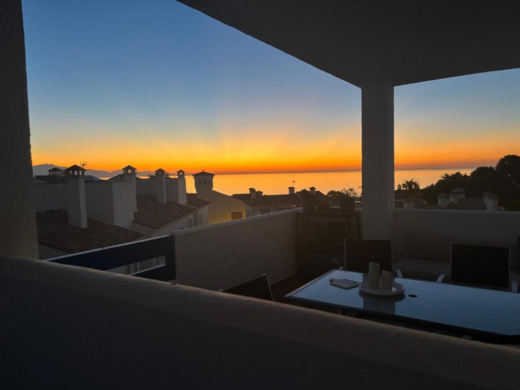 a view of the sunset from the roof of a building at Puerto de la Duquesa MINIMUM 3 NUITS in Manilva