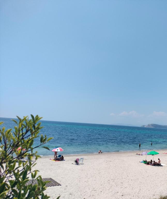 a group of people on a beach with umbrellas at Bougainville Bianco in Quartu SantʼElena