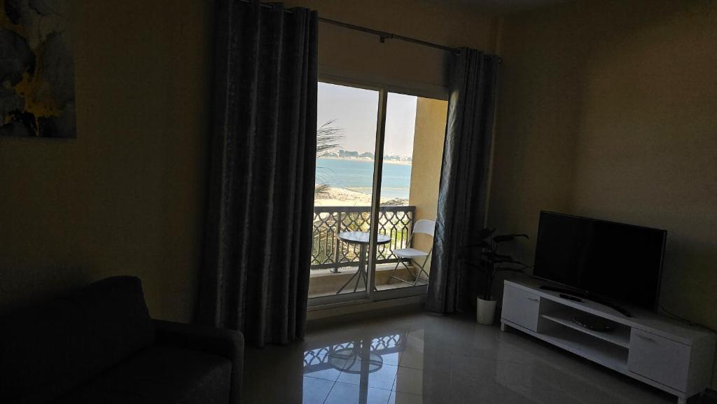 a living room with a television and a view of the ocean at Luxury casino & beach studio in Ras al Khaimah