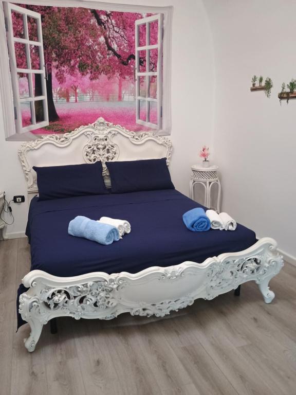Cama blanca con almohadas azules y ventana en Oasi di san Benedetto, en Castellaneta