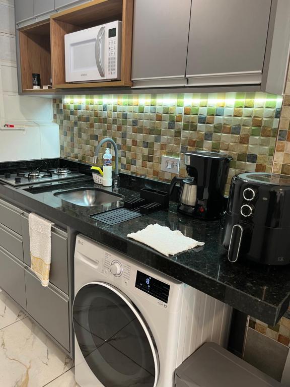a kitchen with a washing machine and a sink at The Flat 311 estacionamento gratuito in Campinas