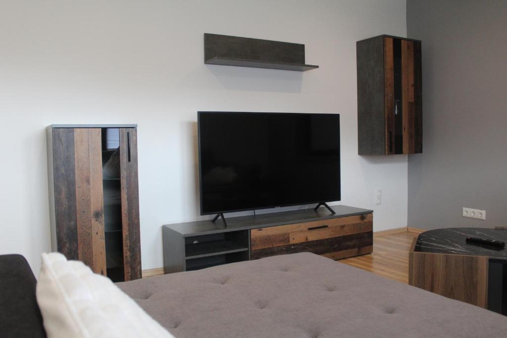 a living room with a flat screen tv on a entertainment center at Blick zur Heide in Volkesfeld