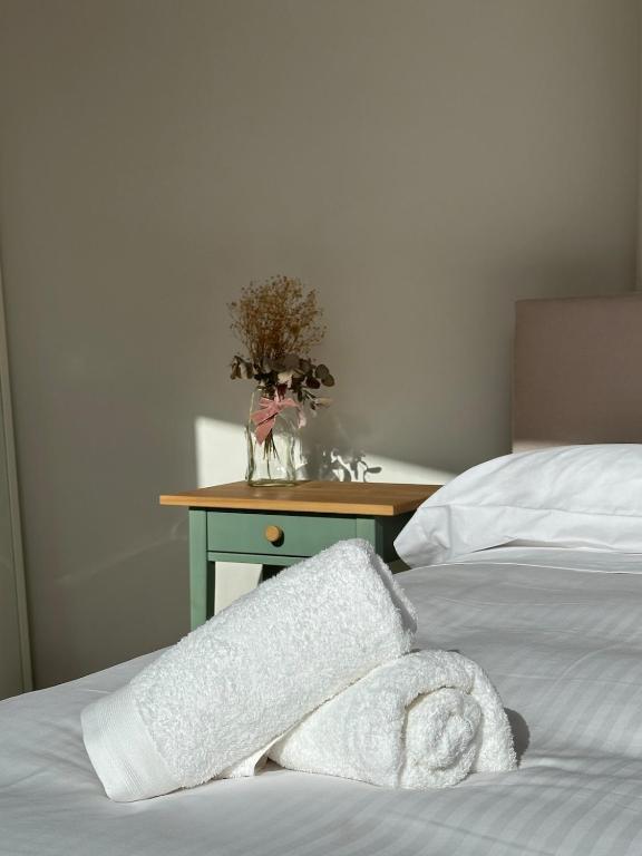 a white towel laying on a bed next to a table at Apartamento Camino a Lancha in Miengo