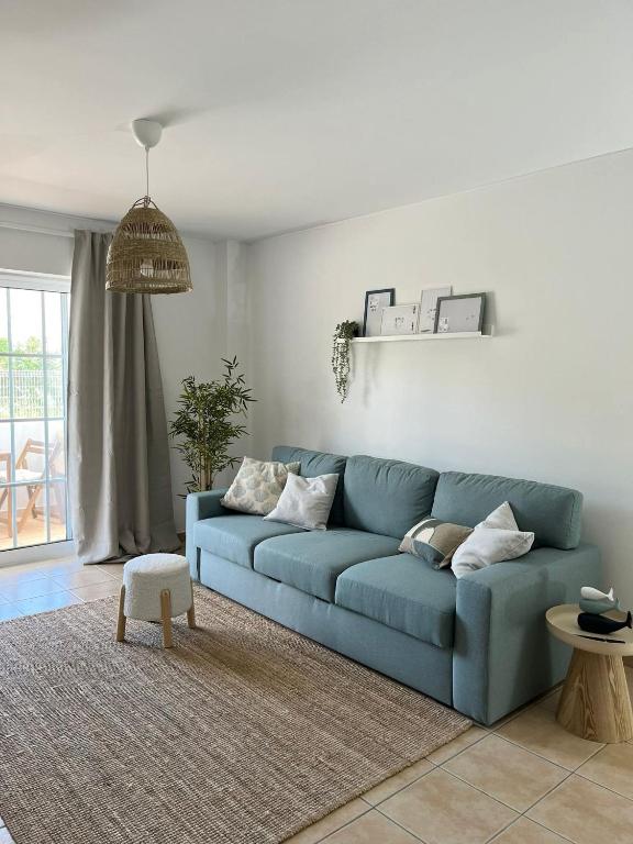 a blue couch sitting in a living room at Cabanas De Miramar in Tavira