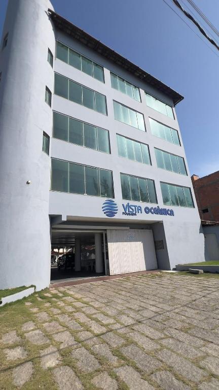 a large building with a nissan controller sign on it at Vista Oceanica Pousada in Marataizes
