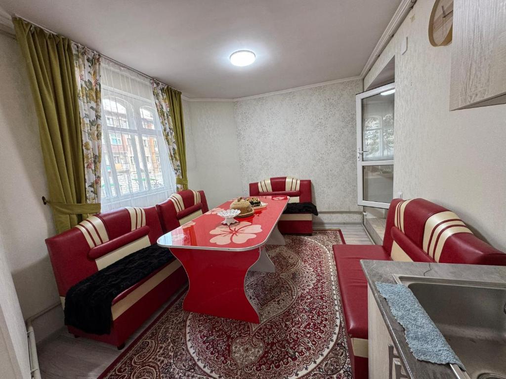comedor con sillas rojas y mesa roja en Квартира, en Karakol