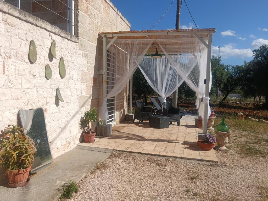 Un pabellón con una cortina blanca y plantas en macetas. en Villa Monsignore 1067, en Triggianello
