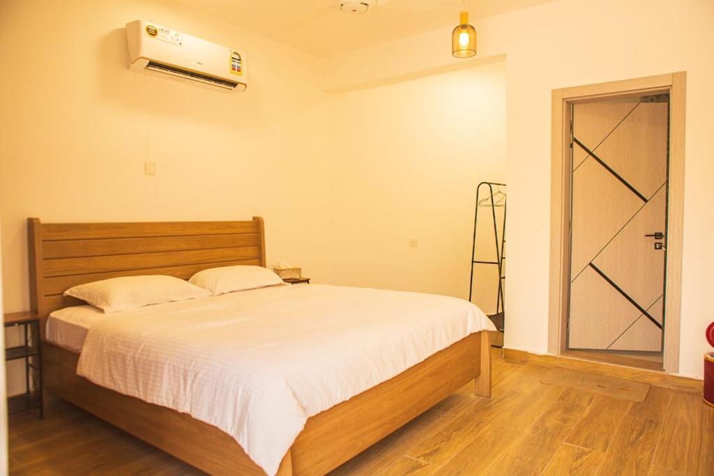 a bedroom with a bed and a door with a fan at Nima guest house in Nizwa