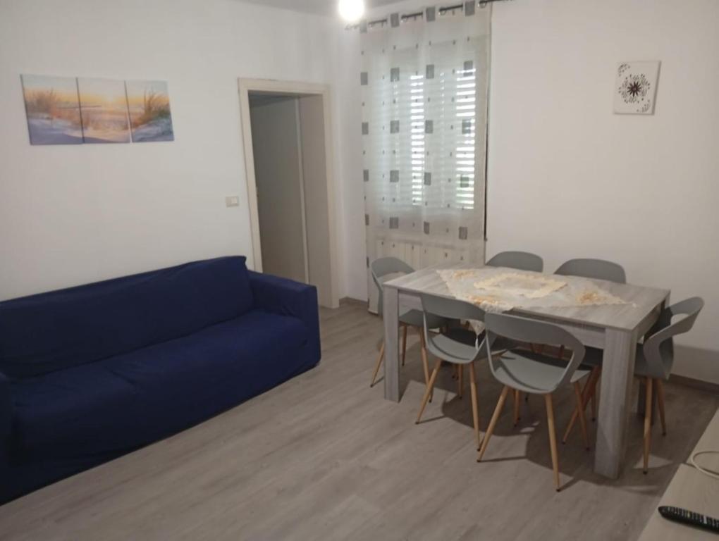 Una sala de estar con un sofá azul y una mesa. en Casa Navacchio, en Navacchio