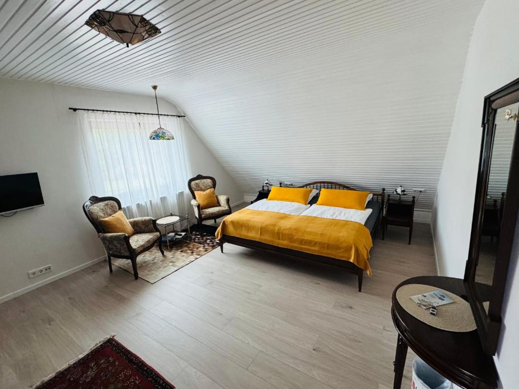 a bedroom with a bed and two chairs and a table at Ferienwohnung Klahn Neue Tiefe in Neue Tiefe Fehmarn