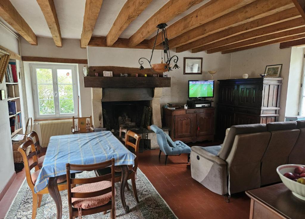 a living room with a table and a fireplace at Berrichonne house near Beauval Zoo in Jeu-Maloches