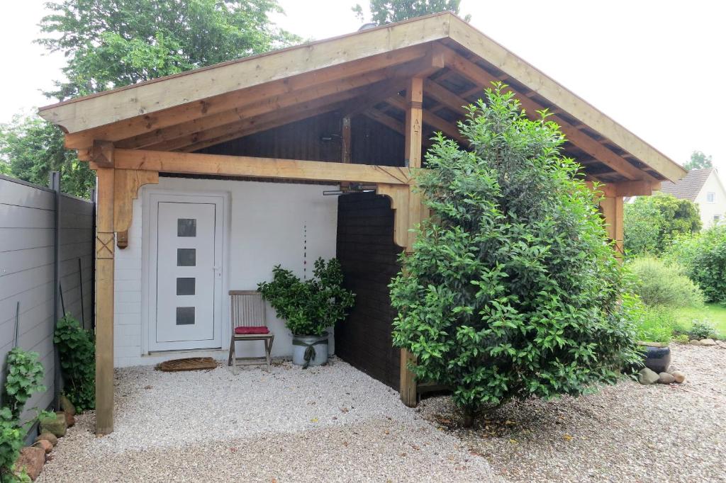a pergola with a white door in a yard at Ferienhaus Brauner Hirsch in Celle