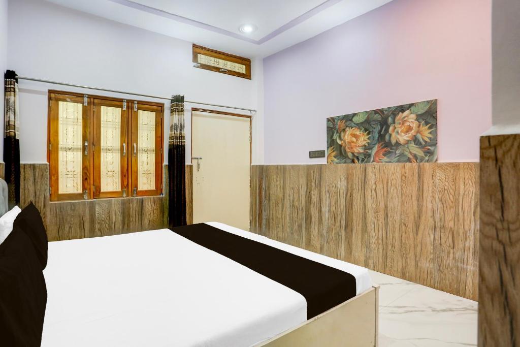 a bedroom with a bed and a painting on the wall at Hotel O GOLD PLAZA HOME STAY in Chandausi