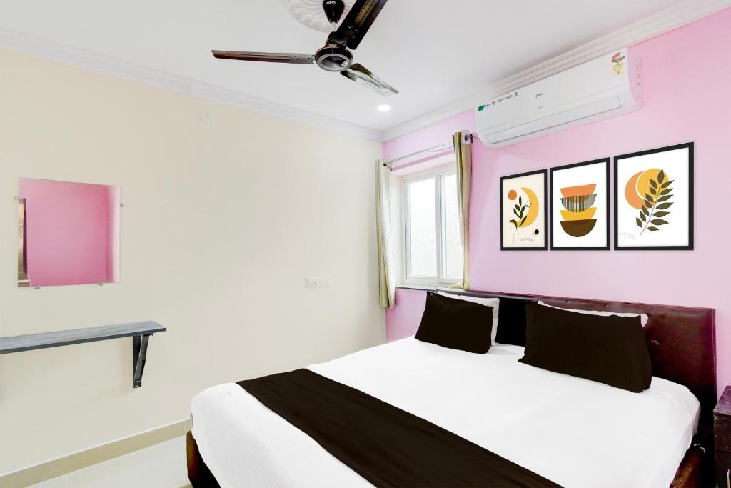 ハイデラバードにあるHotel O Madhu Grand Luxury Roomsのピンクの壁のベッドルーム1室