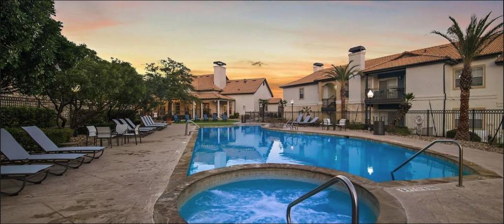 a large swimming pool with chairs and a house at Landing San Antonio Far North Central in San Antonio
