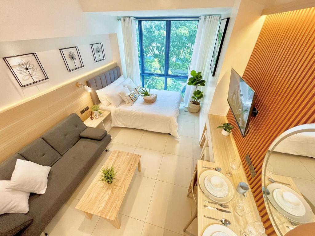 ein Wohnzimmer mit Sofa und Fernseher in der Unterkunft City Garden Inside IT Park Gym & Pool Fast Wi-Fi in Cebu City