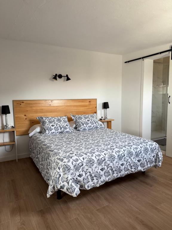 a bedroom with a large bed with a wooden headboard at Casa Saboa in San Bartolomé