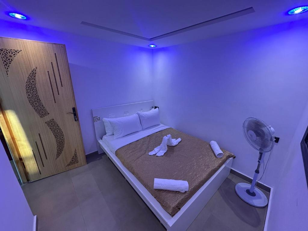 Um pequeno quarto com uma cama, toalhas e um ventilador. em Casa Del Mar Briech em Arzila