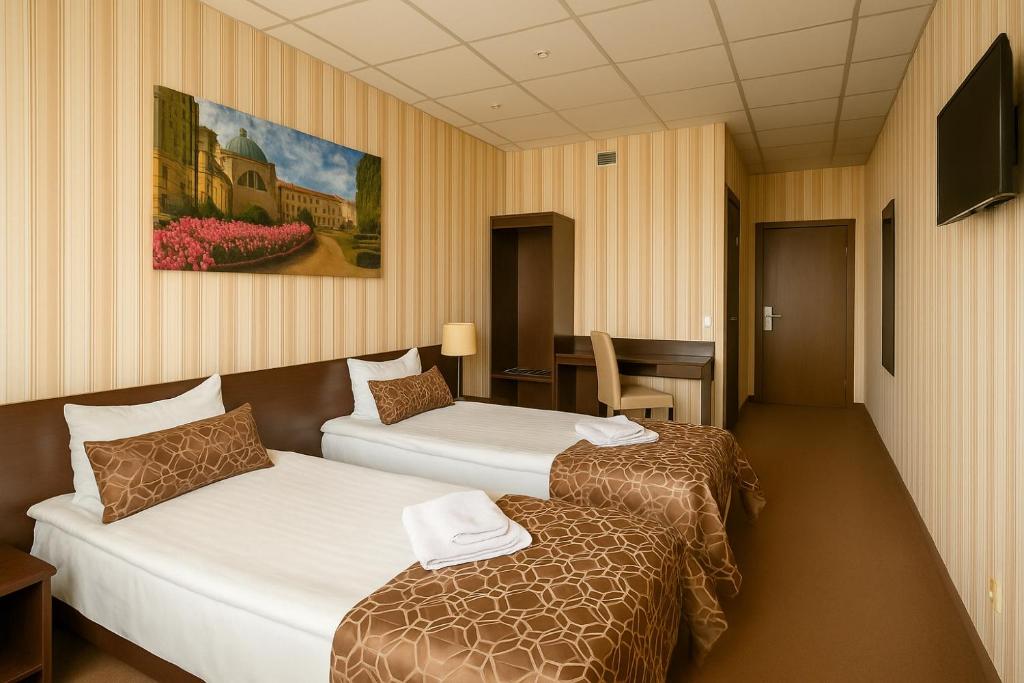 a hotel room with two beds and a table at Vilnius Hotel in Vilnius