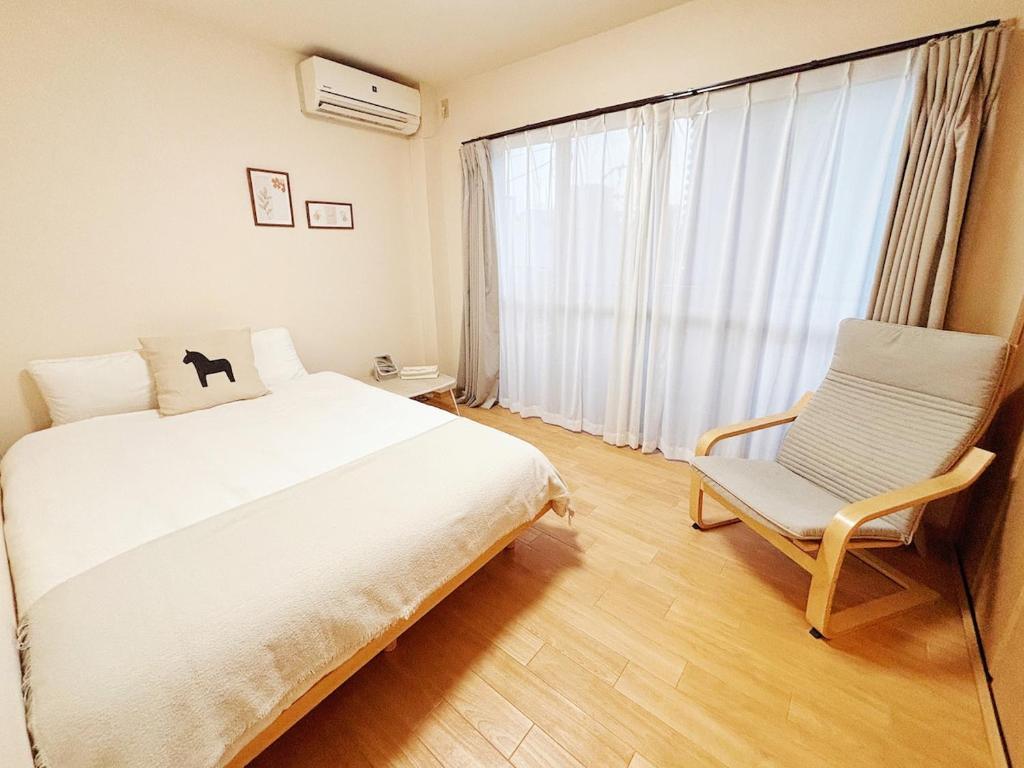 a bedroom with a bed and a chair and a window at 時旅ー大正 in Osaka