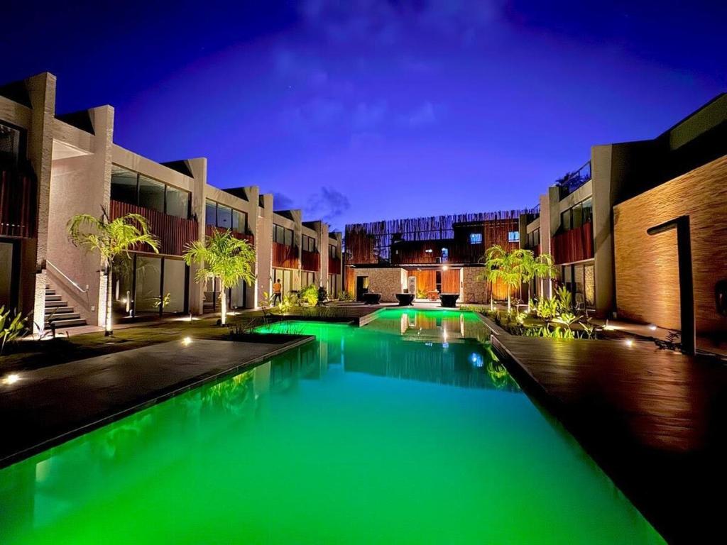 a swimming pool with green lighting in a building at Apartamento Luxo em Japaratinga in Japaratinga