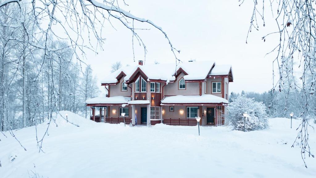 a house in the snow with snow covered trees at Private House by the River in Rovaniemi
