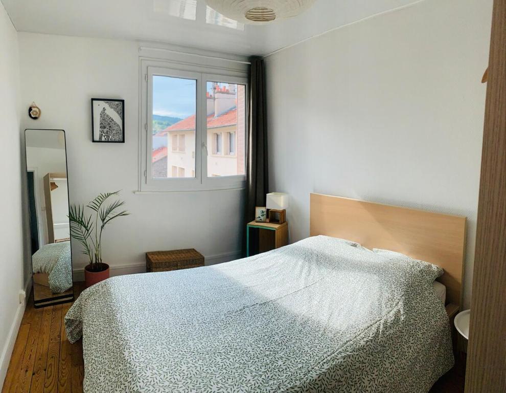 una camera da letto con un letto e una finestra di L'Olivier #Terrasse #Confort a Clermont-Ferrand