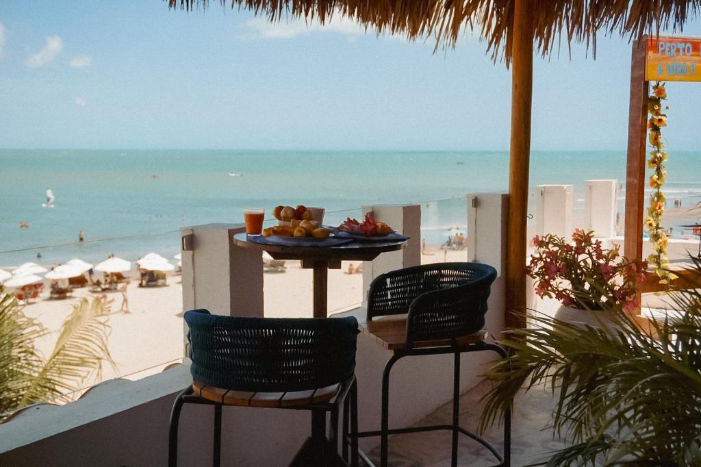 a table with a plate of fruit on the beach at Vila Gallina Pousada in Jericoacoara