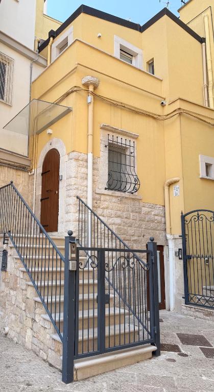 a yellow house with a black gate in front of it at L'Alfiere in Corato