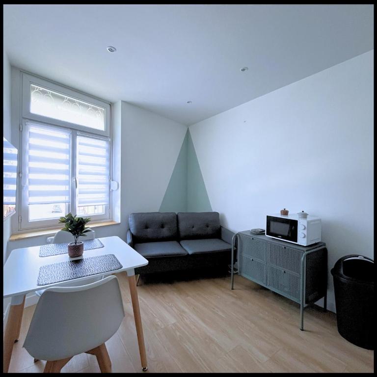 een woonkamer met een bank en een tafel bij SQ'Appart x in Saint-Quentin