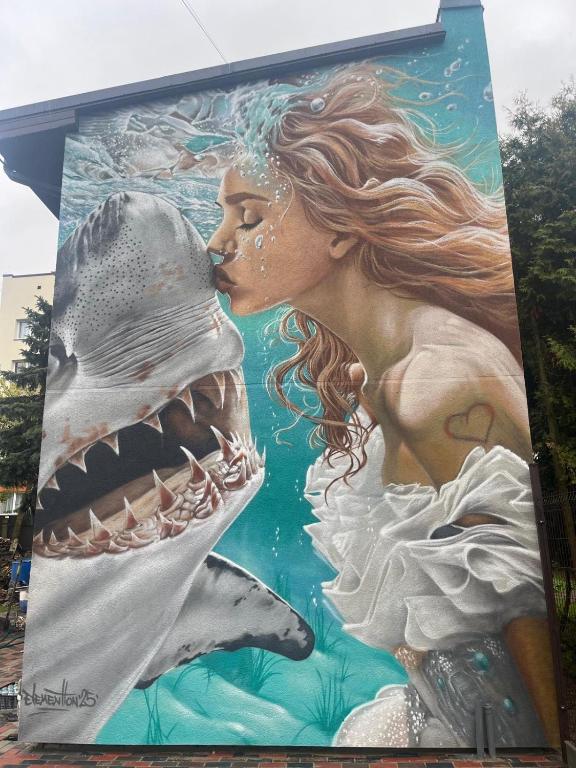 a mural of a mermaid and a shark on a building at Shark in Liepāja