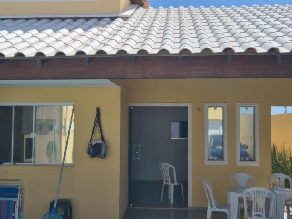 a house with chairs and a table and a roof at Praia Peito de Moça in Luis Correia