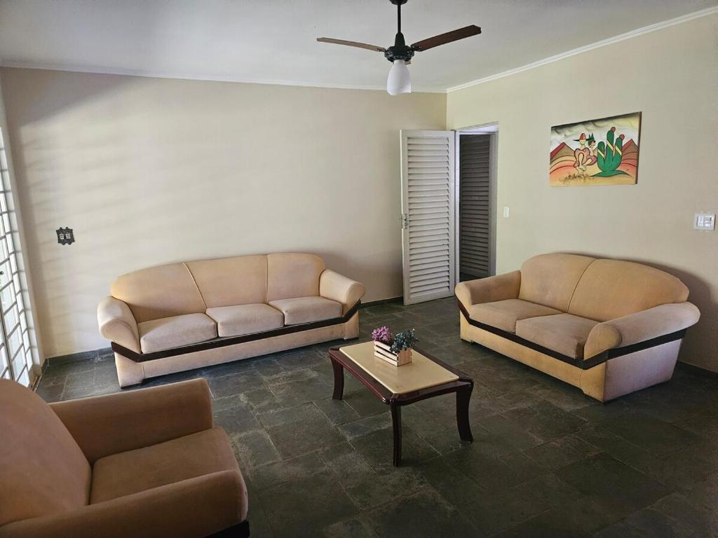 a living room with two couches and a coffee table at Chácara Paraíso Country House Events in Bauru
